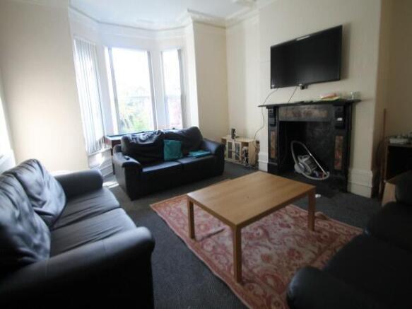 A spacious, well-lit living room featuring comf...