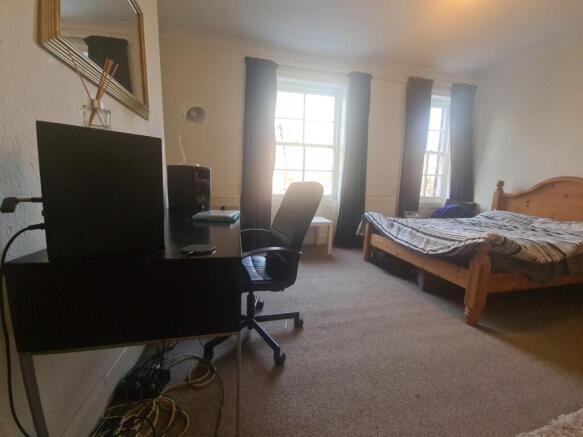 A bright and inviting bedroom featuring a woode...