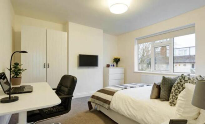 Bright, neatly furnished double bedroom with a ...