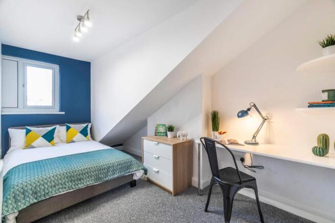 Bright, modern attic bedroom with a comfortable...