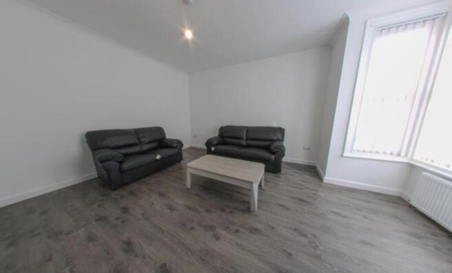 Bright, modern living room with two leather sof...