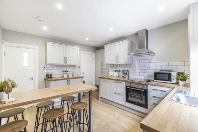 Modern, bright kitchen with light wood countert...