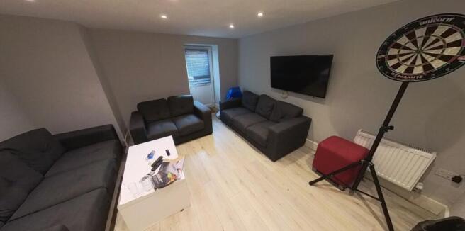 Bright, modern living room with multiple sofas,...