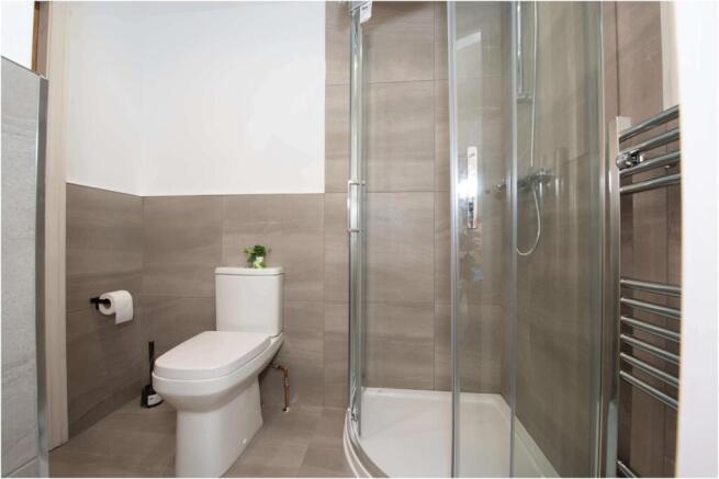 Modern bathroom with a corner glass shower encl...