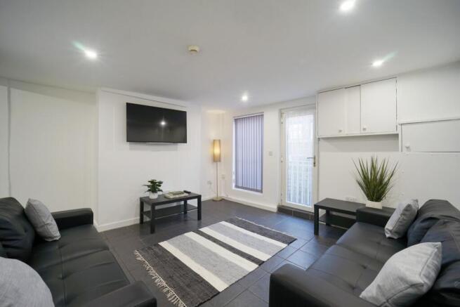 Bright, modern communal living room with two so...