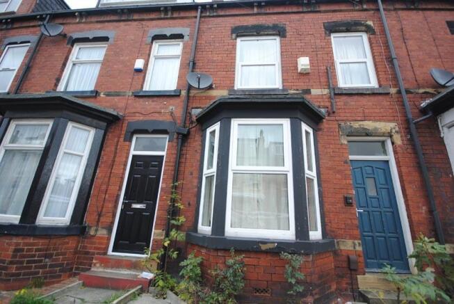 Red-brick terraced house front with bay window,...