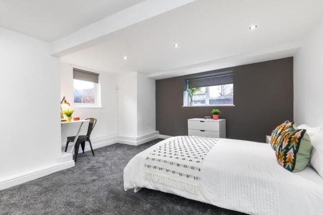 Bright, modern master bedroom with a large bed,...