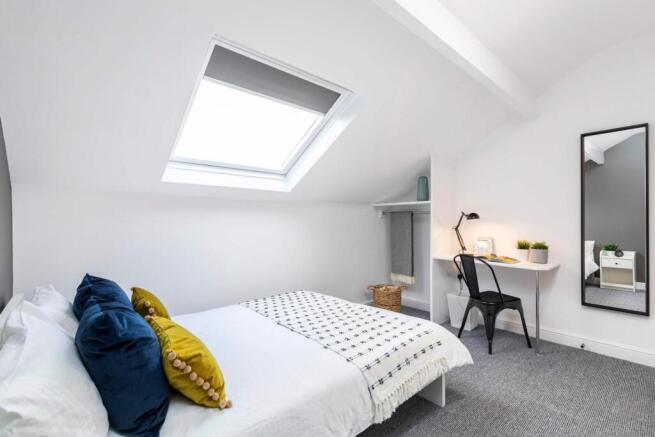 Bright, contemporary attic bedroom with a comfy...