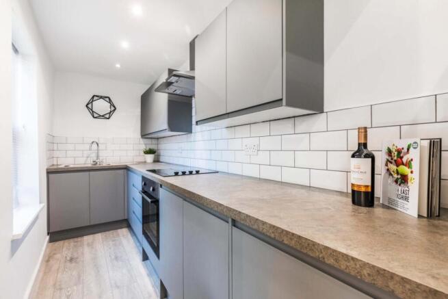 Modern fitted kitchen with grey cabinetry, long...