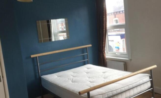 Bright, simply furnished bedroom with a double ...