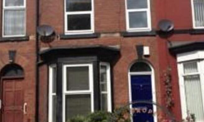 Red-brick terraced house with bay window and a ...