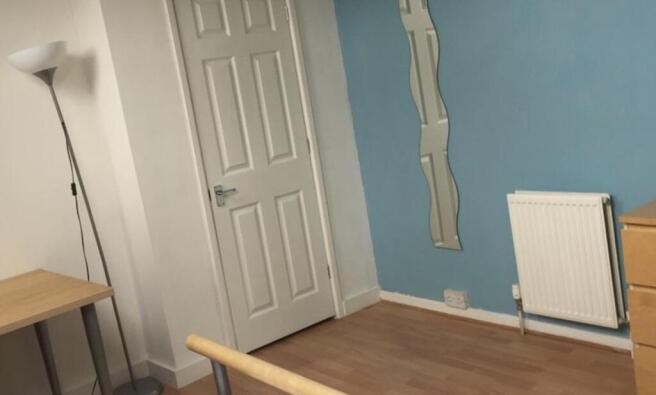 Neat bedroom with light blue feature wall, wood...