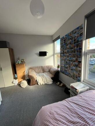 Bright, comfortable bedroom featuring a cozy so...