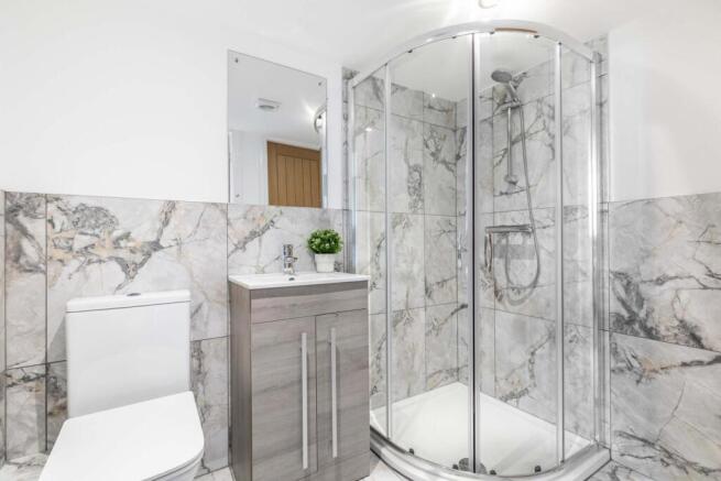 Bright, modern bathroom featuring a corner glas...