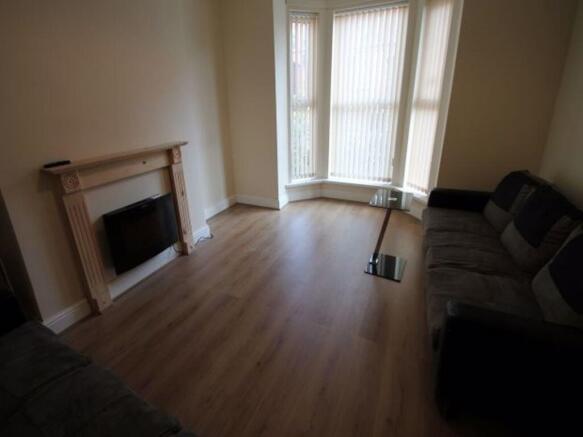 Bright living room with a bay window letting in...