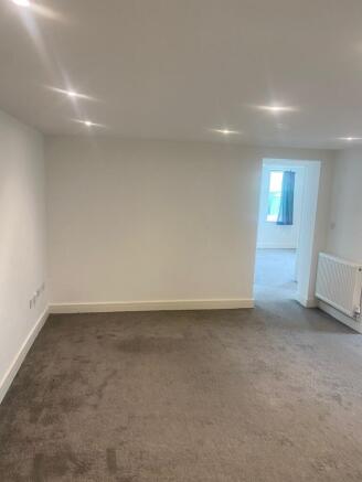 Bright, neutrally decorated living area with re...