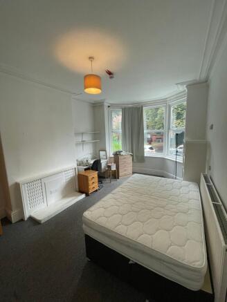 A spacious and well-lit double bedroom with amp...