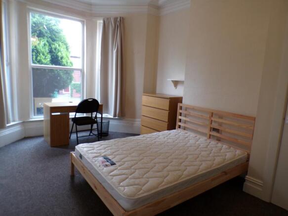 A spacious and bright double bedroom featuring ...