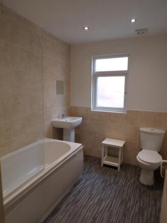 A spacious and modern bathroom featuring a rela...