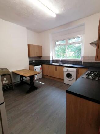 A spacious and well-lit kitchenette with modern...