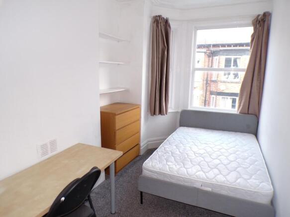 A bright and inviting double bedroom with ample...