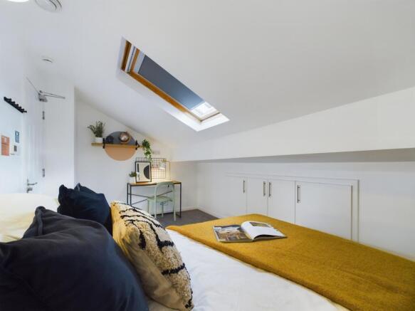 A spacious and bright double bedroom featuring ...