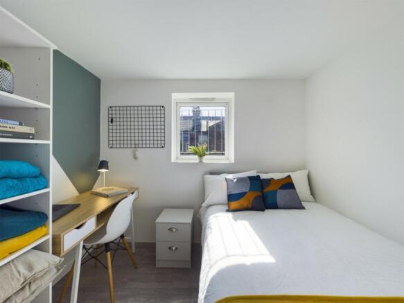 A bright and tidy single bedroom featuring a co...
