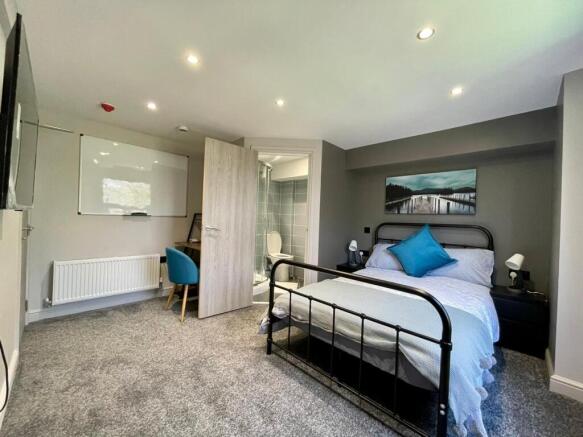 This inviting double bedroom features a comfort...