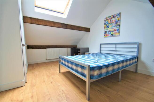 A charming double bedroom featuring a comfortab...