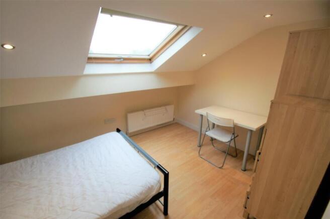 Bright and cozy double bedroom featuring a skyl...