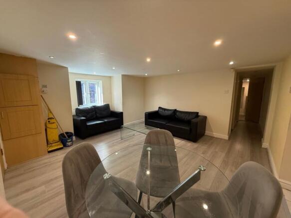 A modern living room featuring sleek black sofa...
