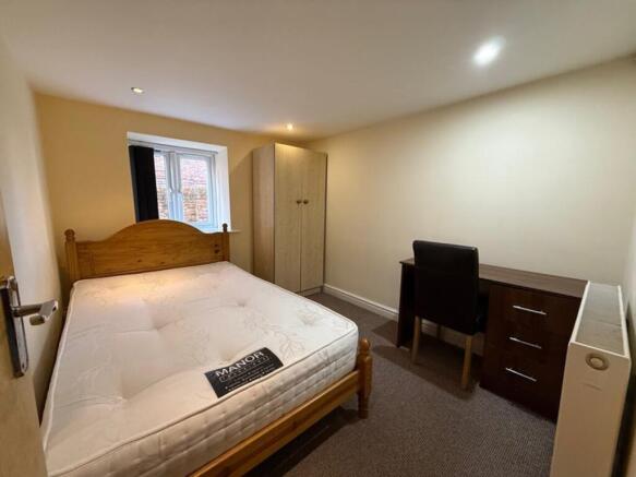 This inviting double bedroom features a comfort...