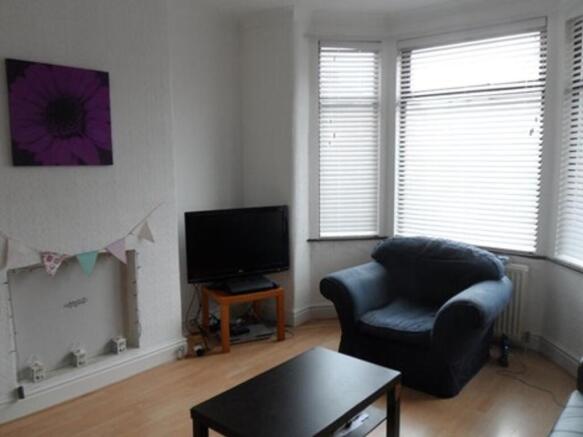 A cozy living room featuring ample natural ligh...