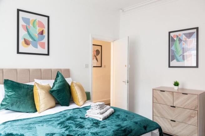 This inviting double bedroom features a stylish...