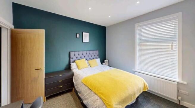 A charming double bedroom featuring a cozy bed ...