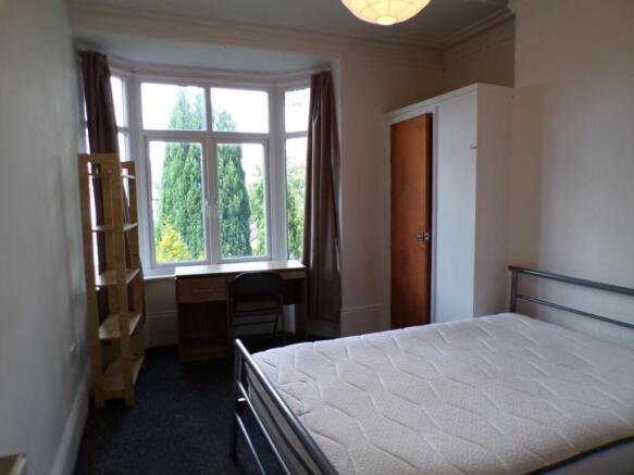 Spacious double bedroom featuring large windows...