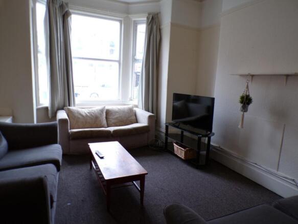 A cozy living room featuring large windows that...