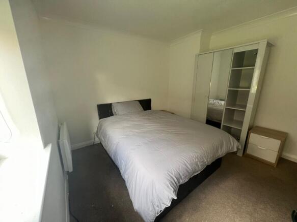 This inviting double bedroom features a comfort...