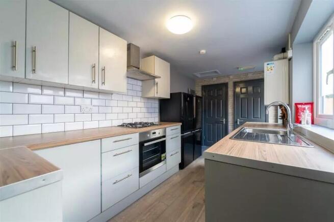 A modern kitchen featuring sleek cabinetry, a s...