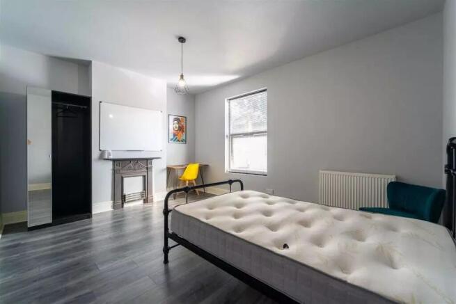Spacious double bedroom featuring a stylish des...