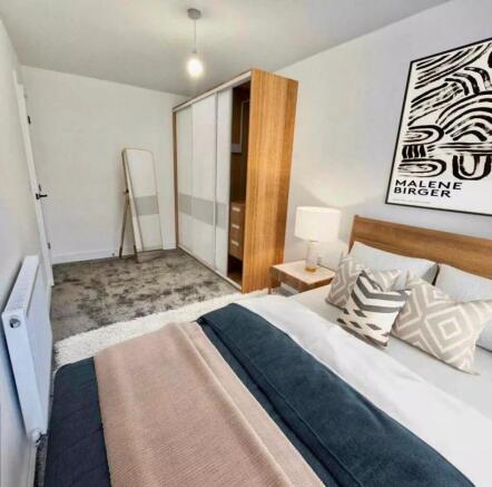 This cozy double bedroom features a stylish des...