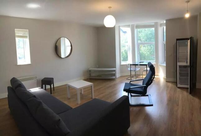Bright and spacious living room featuring large...