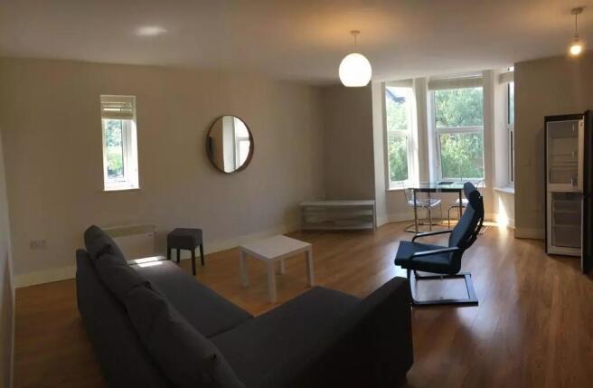 A bright and spacious living room featuring lar...