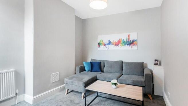 This stylish living room features a modern grey...