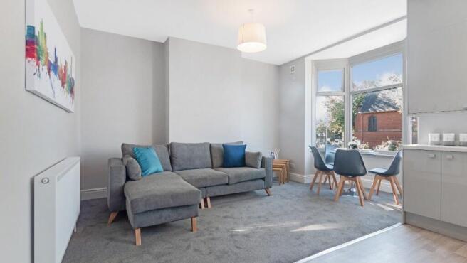 Bright and spacious living room featuring large...