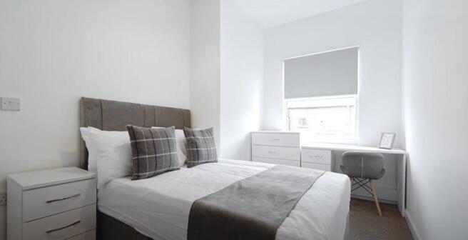 This inviting double bedroom features a cozy be...