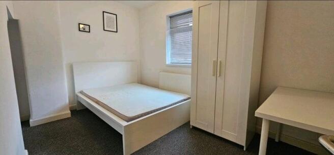 A neat and bright double bedroom featuring a wh...