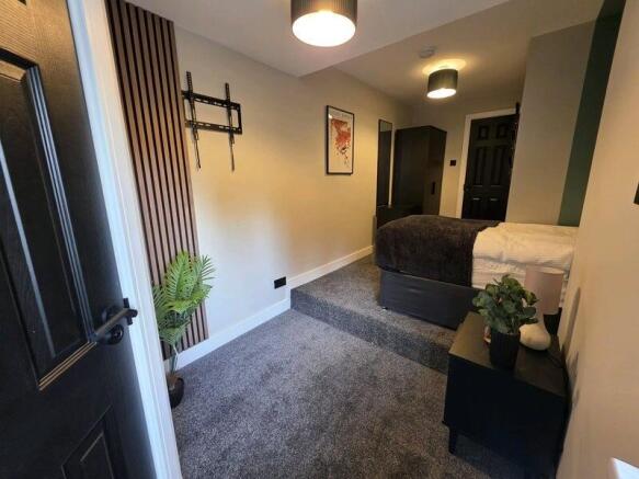 A modern single bedroom with a cozy bed raised ...