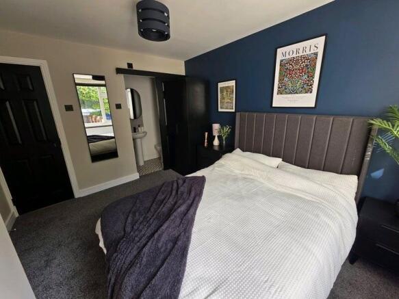 A stylish master bedroom featuring a comfortabl...