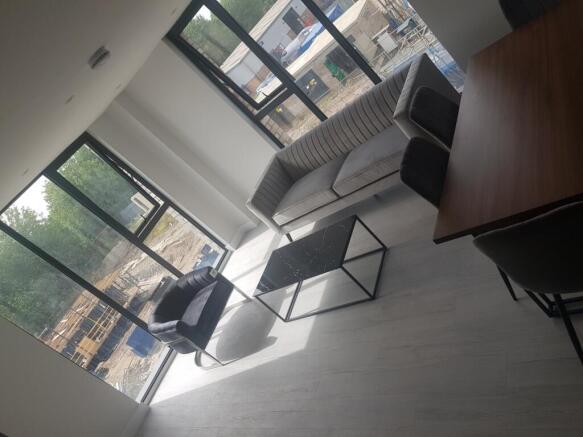 Bright and modern living room featuring large w...